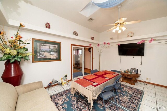 game room featuring light tile patterned floors, visible vents, a ceiling fan, lofted ceiling with skylight, and baseboards