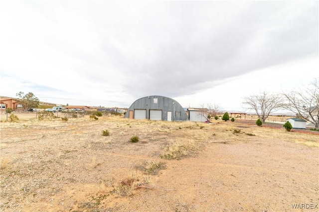 view of yard with a garage and an outbuilding