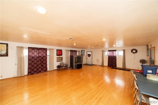 miscellaneous room featuring a wood stove, visible vents, and wood finished floors