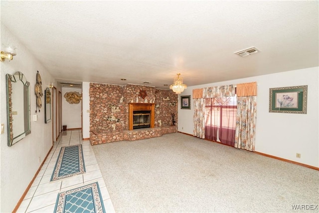 unfurnished living room with a textured ceiling, light colored carpet, visible vents, baseboards, and a brick fireplace