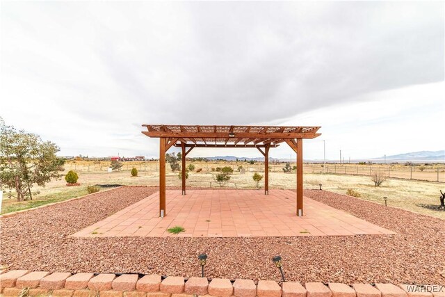 view of home's community with a patio, a rural view, a mountain view, fence, and a pergola