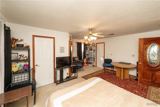 bedroom with light carpet, visible vents, and a ceiling fan