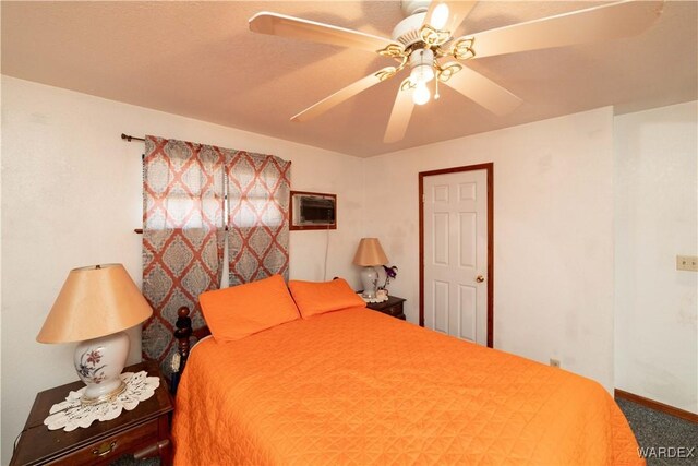 carpeted bedroom featuring a wall unit AC, a ceiling fan, and baseboards