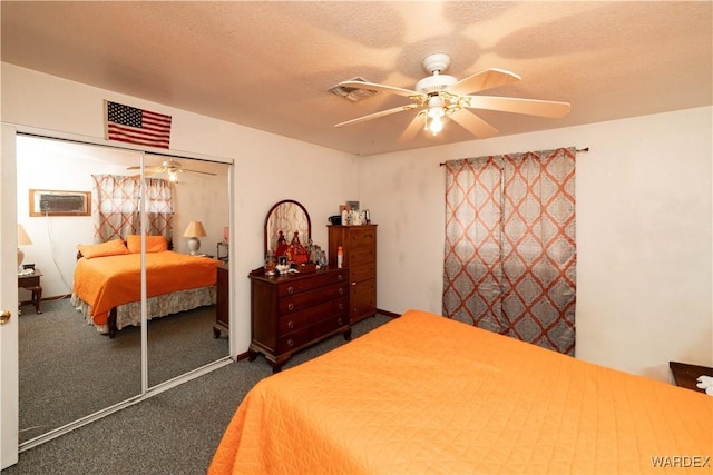 bedroom with a textured ceiling, ceiling fan, visible vents, a closet, and dark colored carpet