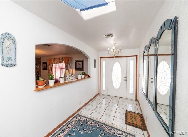 entryway featuring light tile patterned floors, baseboards, visible vents, and a notable chandelier