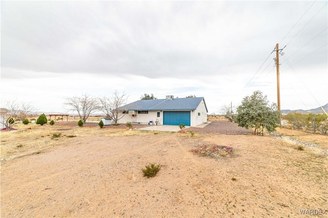 exterior space featuring a garage and dirt driveway