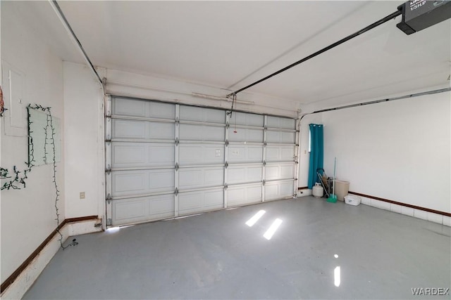 garage with baseboards and a garage door opener