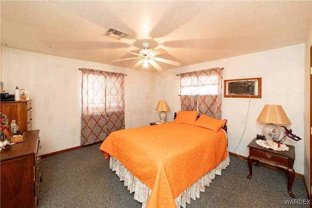 carpeted bedroom featuring a ceiling fan, a wall mounted air conditioner, visible vents, and baseboards