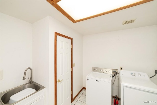 washroom featuring laundry area, visible vents, a sink, and washer and clothes dryer