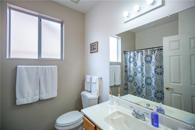 bathroom with toilet, visible vents, and vanity