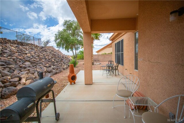 view of patio with outdoor dining area and fence