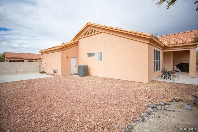 back of property with central air condition unit, a patio area, fence, and stucco siding