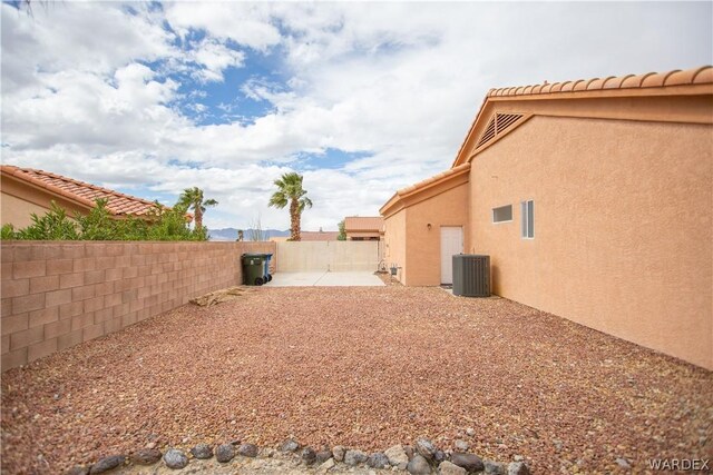 view of yard featuring a fenced backyard, central AC, and a patio