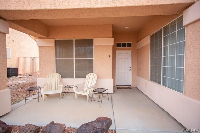 view of exterior entry with a patio area, visible vents, and stucco siding