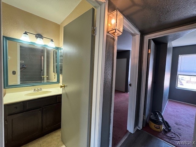 bathroom featuring a textured wall and vanity