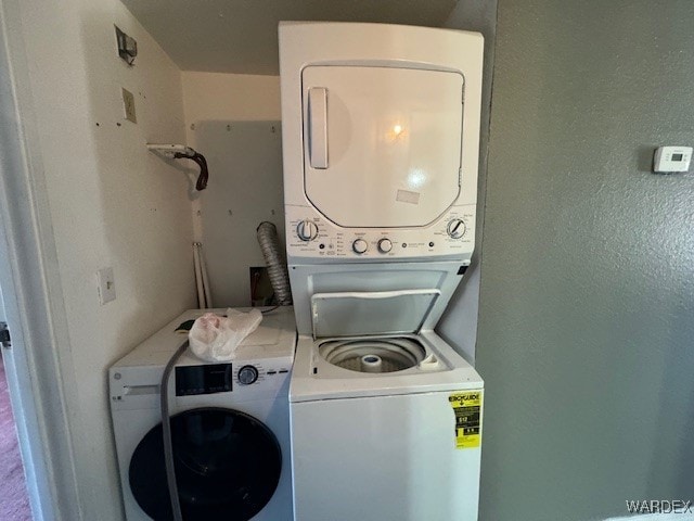 clothes washing area featuring stacked washer / dryer and laundry area