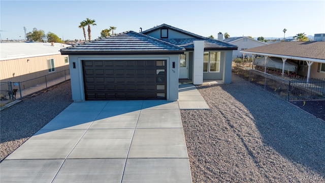 ranch-style home with an attached garage, fence, concrete driveway, and stucco siding