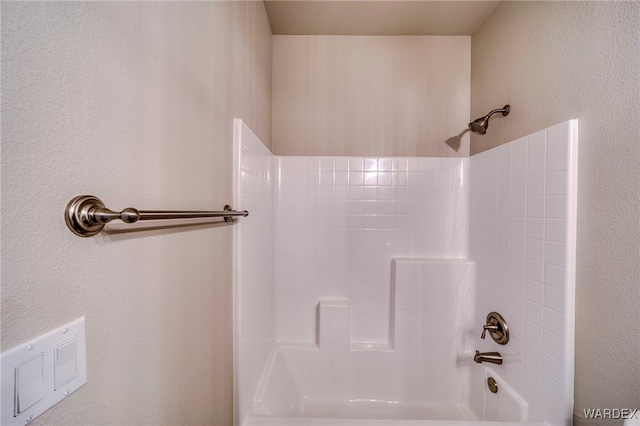 full bathroom featuring shower / bathtub combination and a textured wall