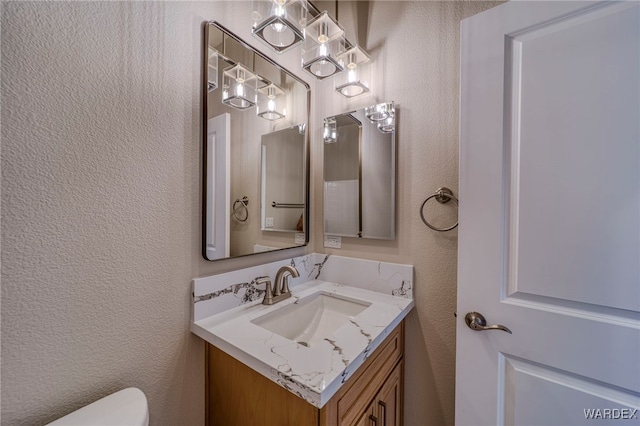 bathroom with a textured wall and vanity