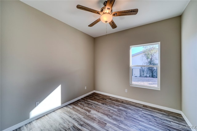 spare room with ceiling fan, wood finished floors, and baseboards