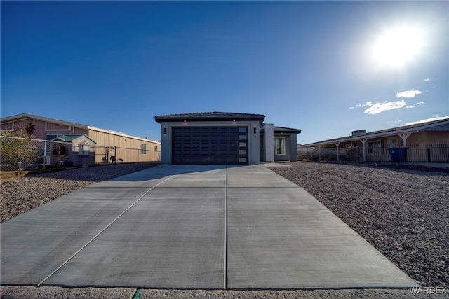 view of front of house with a garage, fence, concrete driveway, and stucco siding