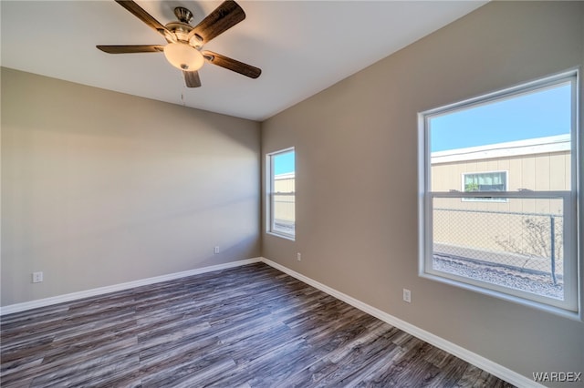 unfurnished room featuring a ceiling fan, baseboards, and dark wood-style flooring