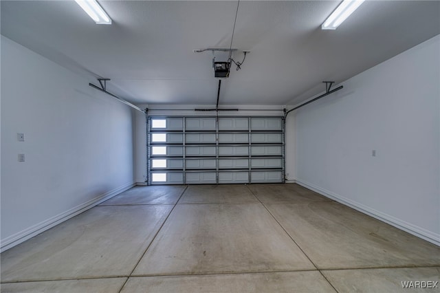 garage with baseboards and a garage door opener