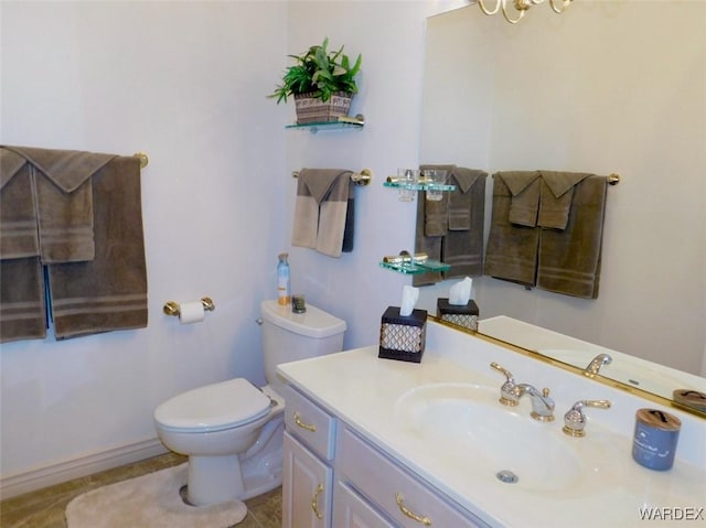 bathroom featuring toilet, tile patterned flooring, baseboards, and vanity