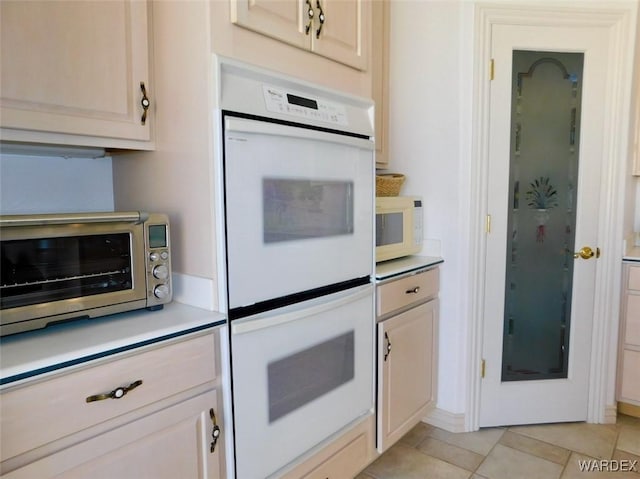 kitchen featuring light countertops, white appliances, light tile patterned flooring, and a toaster