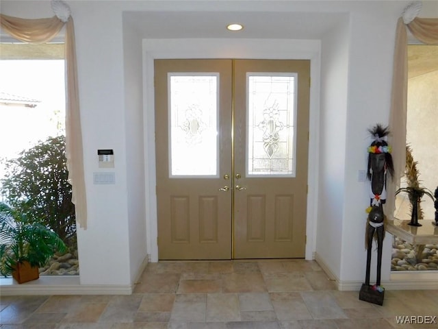 foyer featuring recessed lighting, stone finish flooring, baseboards, and french doors