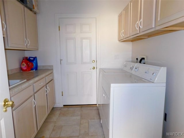 washroom featuring light tile patterned floors, cabinet space, and washer and dryer