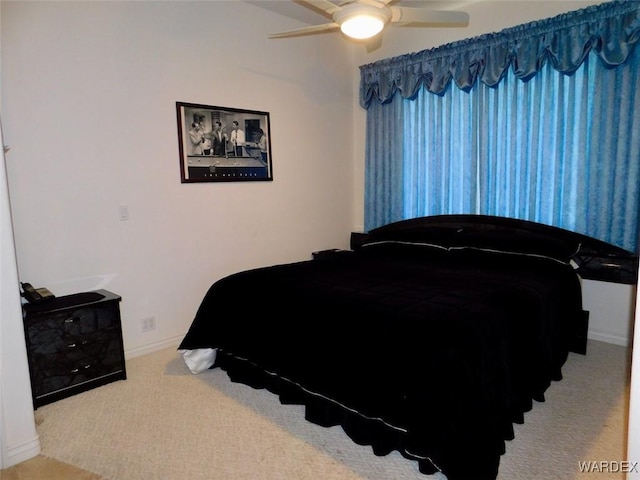 carpeted bedroom with a ceiling fan and baseboards