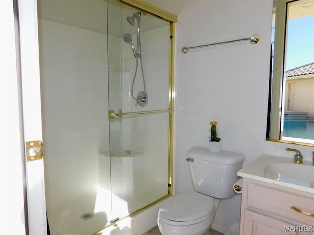 bathroom featuring a stall shower, vanity, and toilet