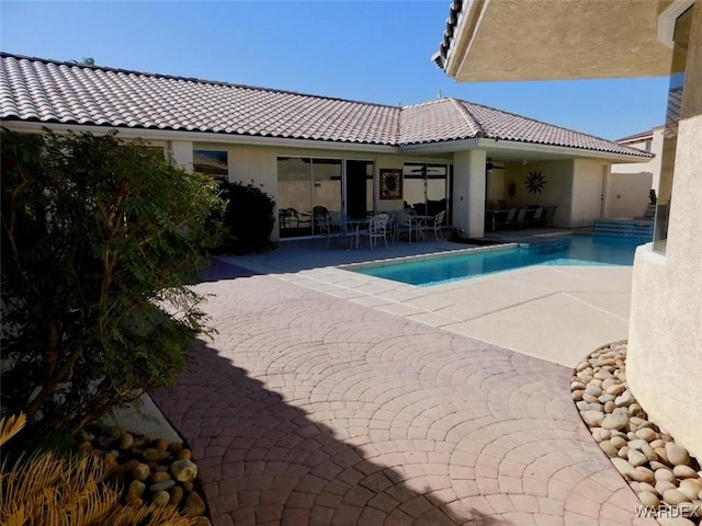 outdoor pool featuring ceiling fan and a patio