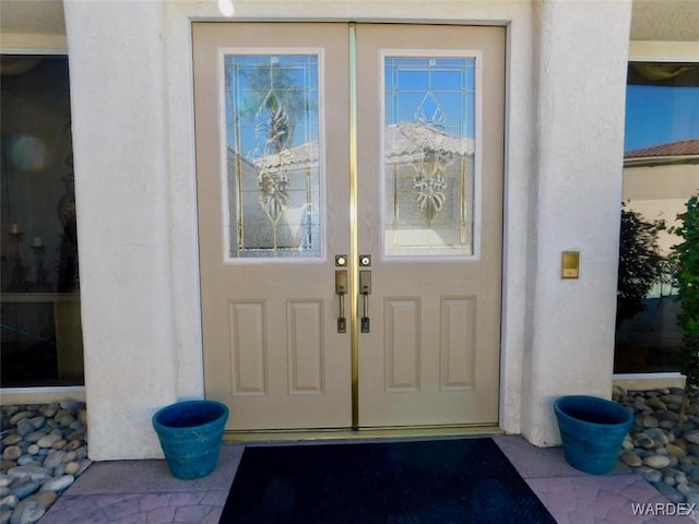 view of exterior entry featuring stucco siding