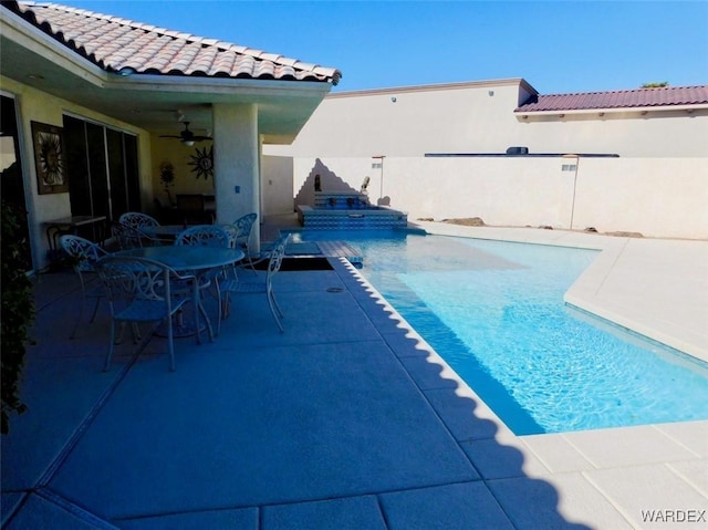 view of swimming pool with ceiling fan, outdoor dining area, a patio area, and a fenced in pool