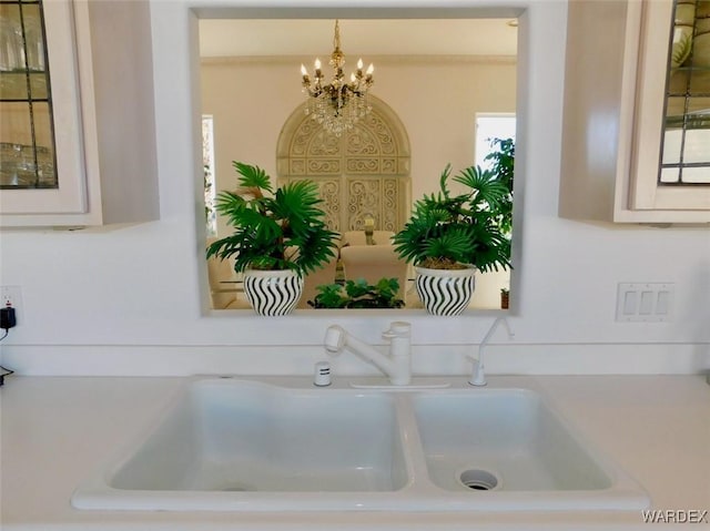 interior details featuring hanging light fixtures, a sink, and an inviting chandelier