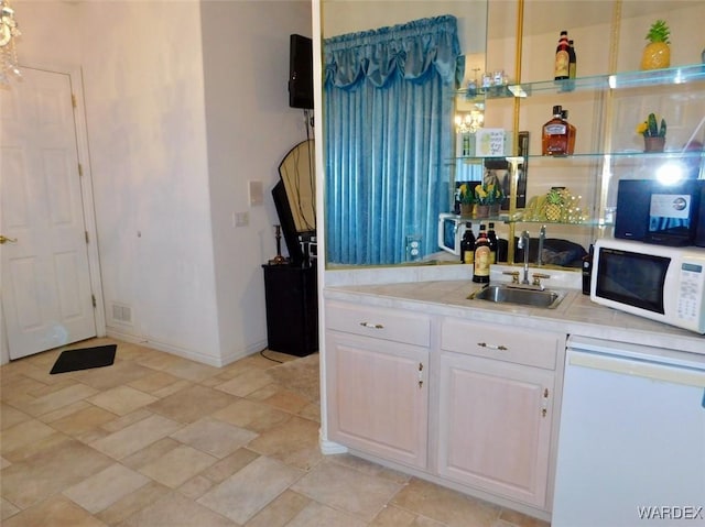 kitchen featuring light countertops, white appliances, a sink, and white cabinets