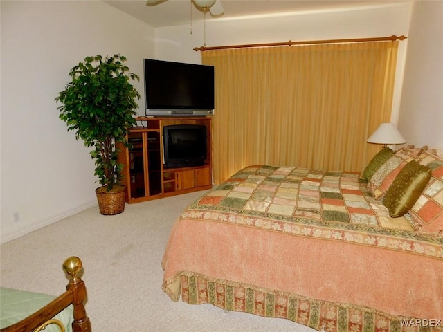 carpeted bedroom featuring baseboards and a ceiling fan