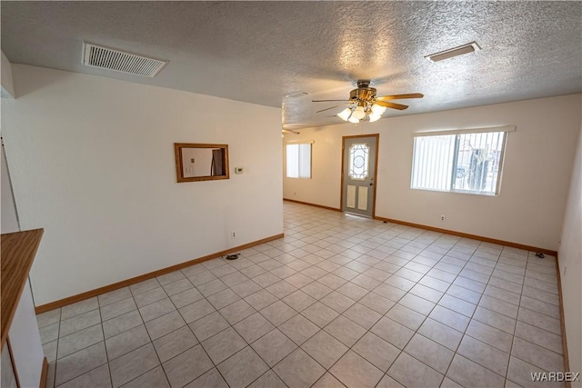 unfurnished room with a ceiling fan, visible vents, and baseboards