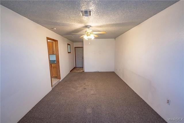 unfurnished room featuring light carpet, ceiling fan, a textured ceiling, and visible vents