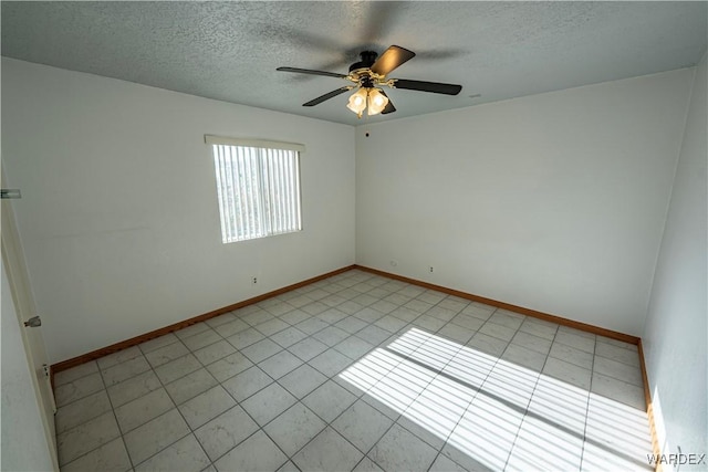 empty room featuring a ceiling fan, light tile patterned floors, baseboards, and a textured ceiling