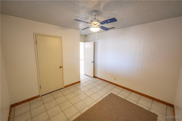 unfurnished room featuring light tile patterned floors, ceiling fan, baseboards, and a textured ceiling