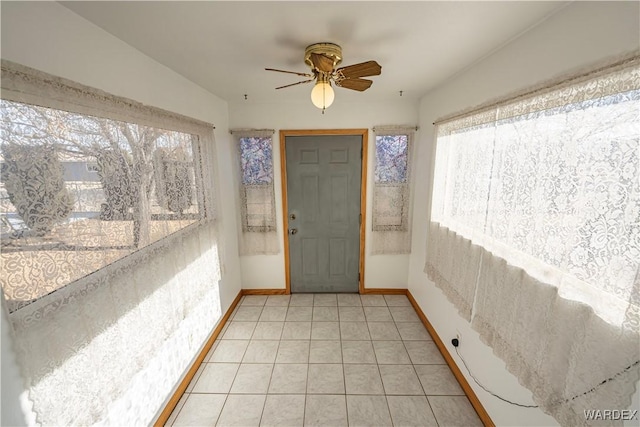 sunroom / solarium featuring a ceiling fan