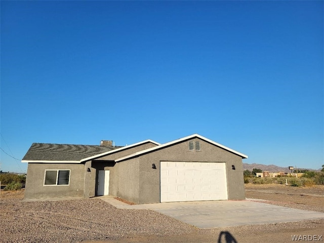 view of front of property featuring concrete driveway, an attached garage, and stucco siding