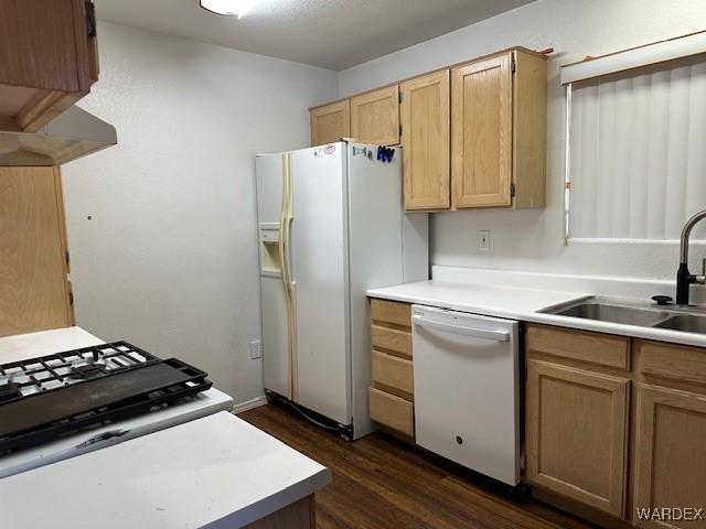 kitchen featuring white appliances, dark wood-style flooring, light countertops, and a sink