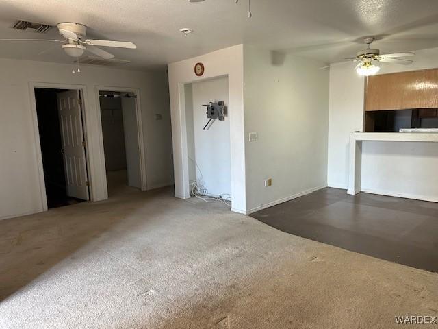 unfurnished living room with visible vents and ceiling fan