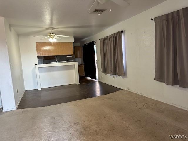 kitchen featuring a ceiling fan, visible vents, and a peninsula