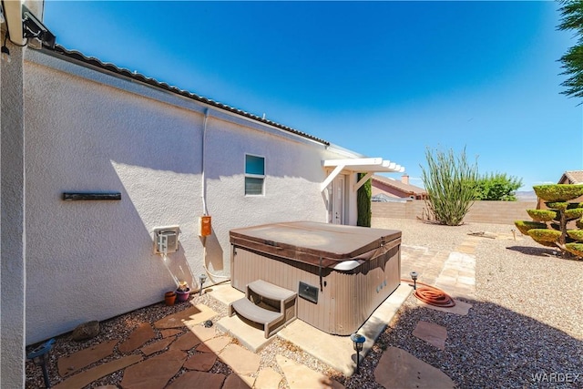 view of patio / terrace featuring a hot tub and a fenced backyard