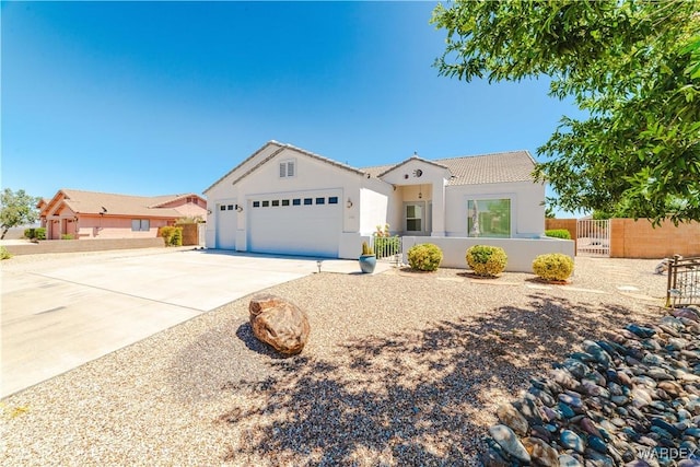 mediterranean / spanish-style home with concrete driveway, a fenced front yard, an attached garage, and stucco siding